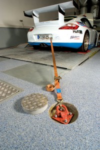 Car in mechanic shop rests on top of alternative flooring.