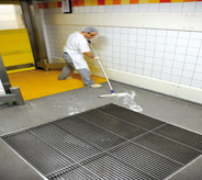 Worker uses best practice to remove water from resistant floor.