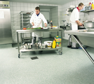 Cook preps food in kitchen area on cart that can move easily across floor.